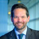 Lukas Mandl, ein Mann mittleren Alters mit Bart, Anzug und Krawatte