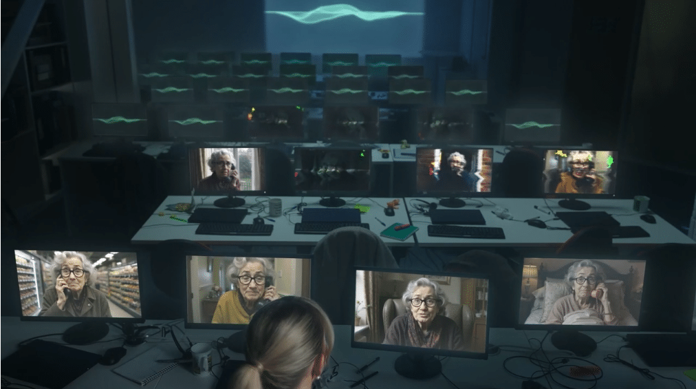 Screenshot from video in https://news.virginmediao2.co.uk/o2-unveils-daisy-the-ai-granny-wasting-scammers-time/ Ein dunkler Saal mit vielen Bildschirmen, auf denen lauter KI-Omas zu sehen sind